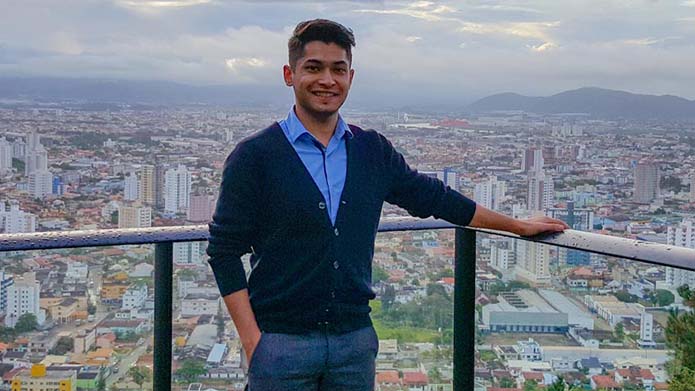 Nidal Islam on a balcony with the cityscape of Itajaí, Brazil behind him.