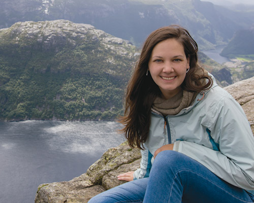 Paula Larsson poses in front of a beautiful mountain range.