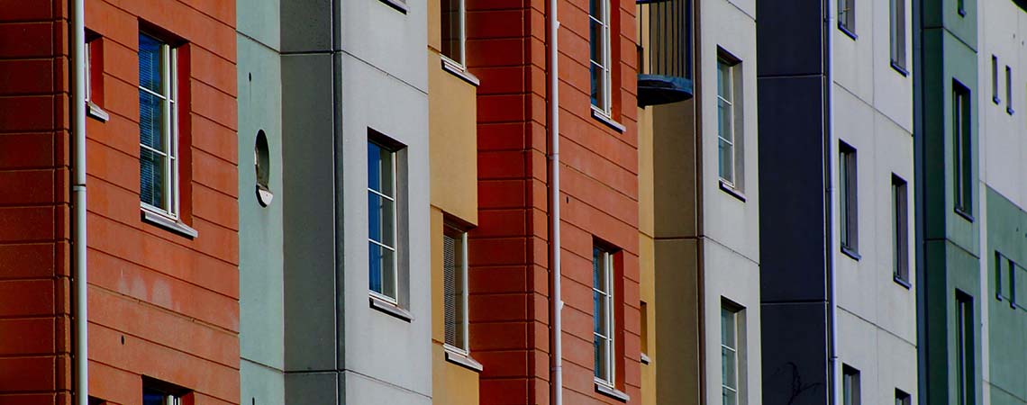 A row of the sides of several multicoloured houses.