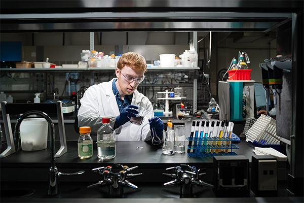 A chemist in a lab mixing chemicals.