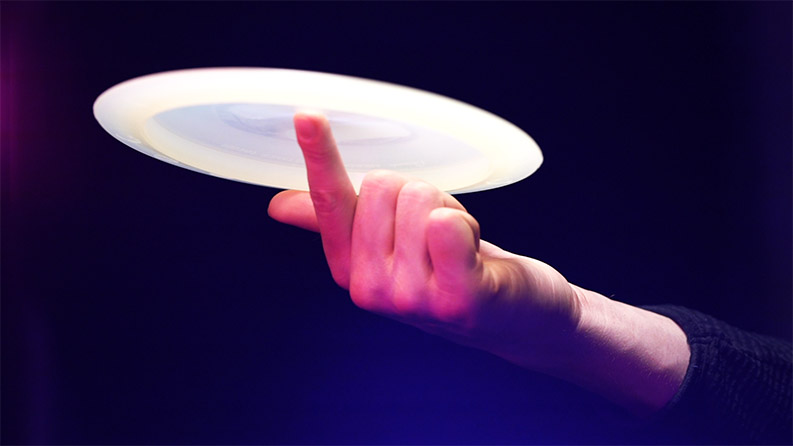 A throwing disc spinning on a finger.