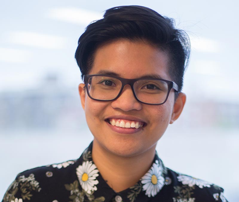 Carille Mendoza smiling in a bright-coloured, patterned shirt.