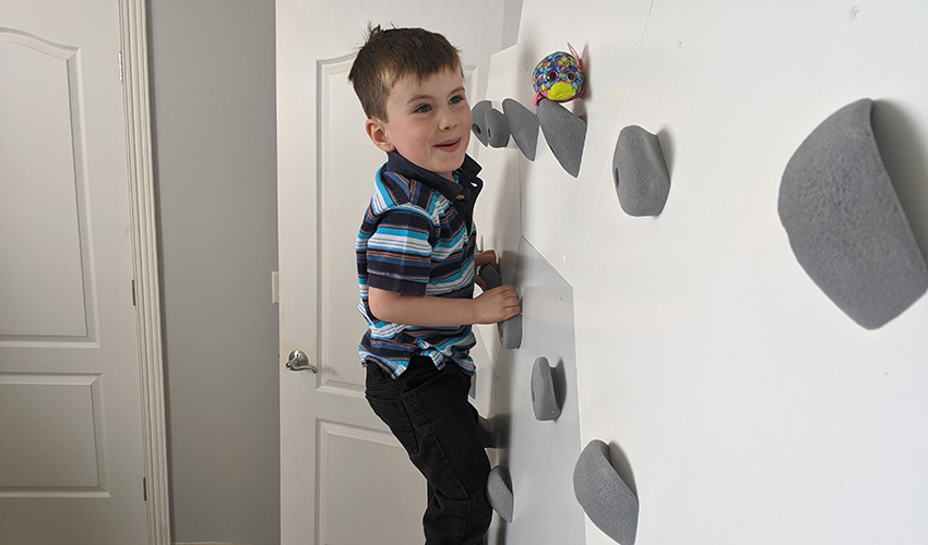 A child climbing on an at-home climbing wall.