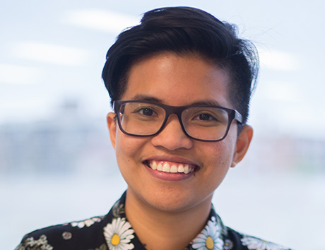 Carille Mendoza smiling in a bright-coloured, patterned shirt.