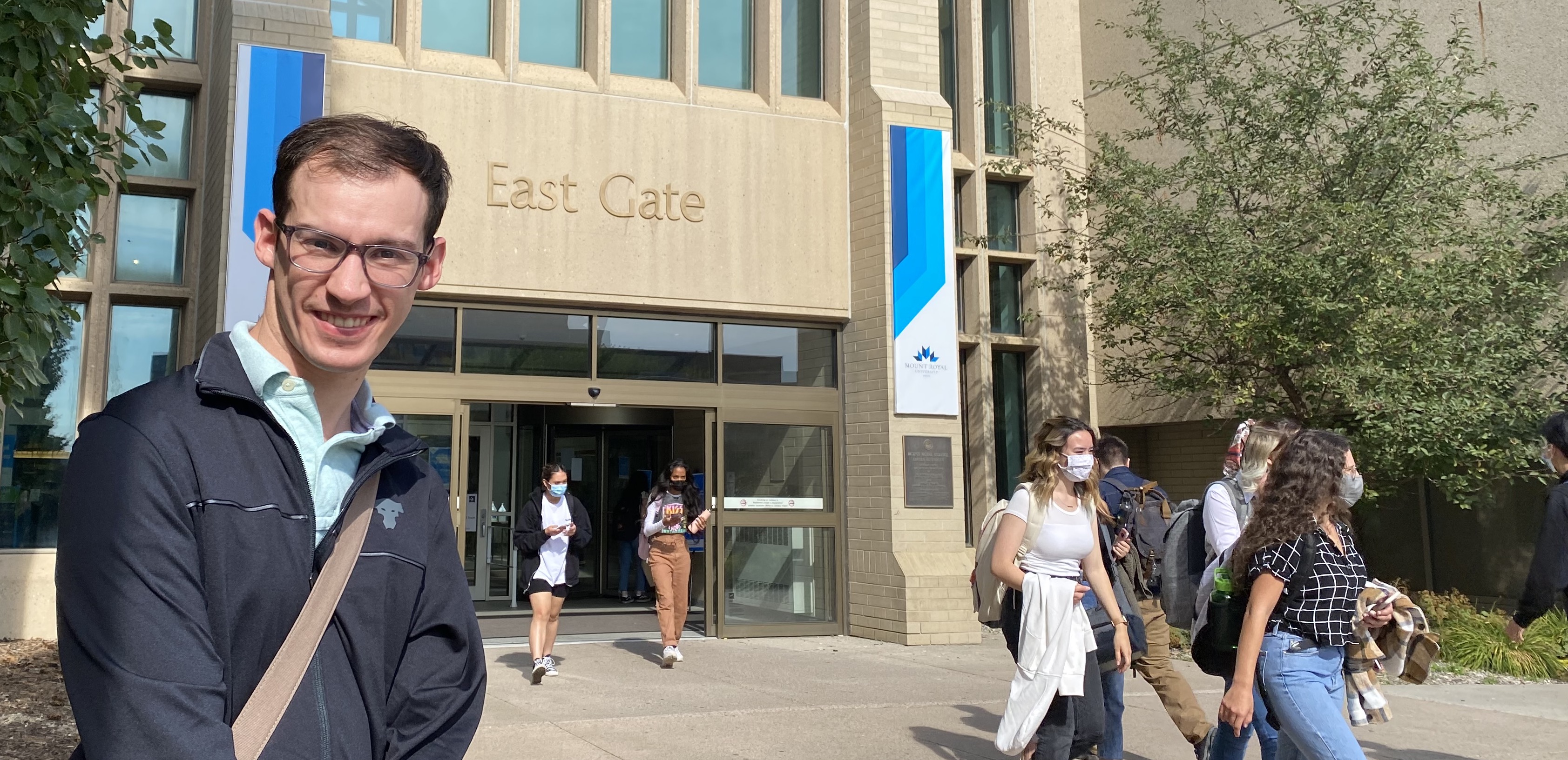 Student Will Dodge-Smith stands outside of the East Gate entrance on the Mount Royal campus.