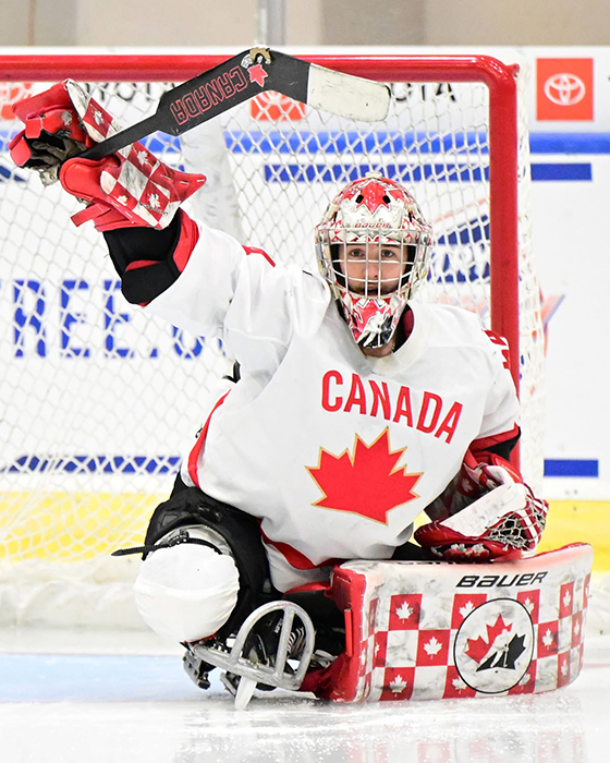 Para-hockey goalie Adam Kingsmill of Team Canada raising his goalie stick in a celebratory gesture.