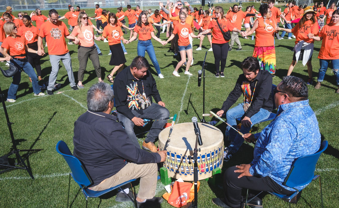 Individuals in orange shirts in a lively outdoor setting.
