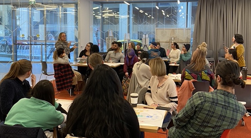 Photo of mentors and coaches meeting with students at the Central Library.