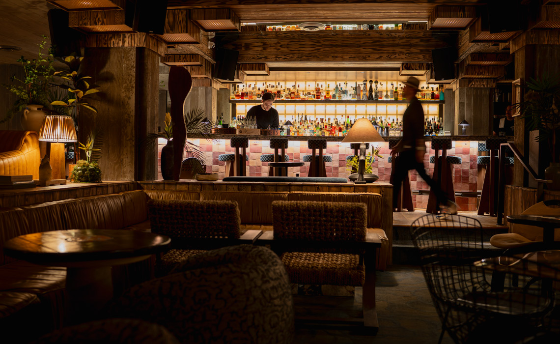 A bar featuring a polished counter and several chairs arranged for patrons.