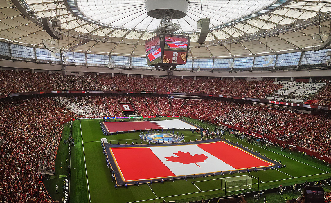 Flags for Canada and Qatar are displayed on the pitch during the national anthems before a FIFA World Cup.