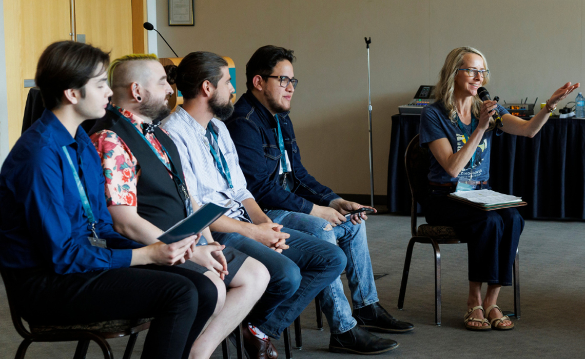 A group of people seated in chairs engaged in conversation, sharing ideas and interacting with one another.
