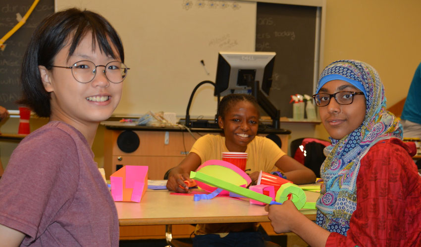 Three kids doing crafts at an MRUKids camp.