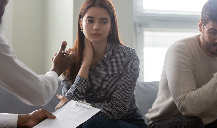 Male social worker talking to two people who look a bit upset.