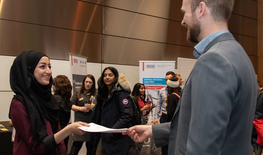 Photo of student submitting a resume at the career fair.