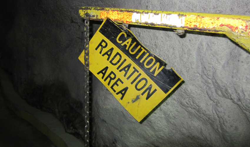Photo of a sign in the mine that reads caution radiation area.