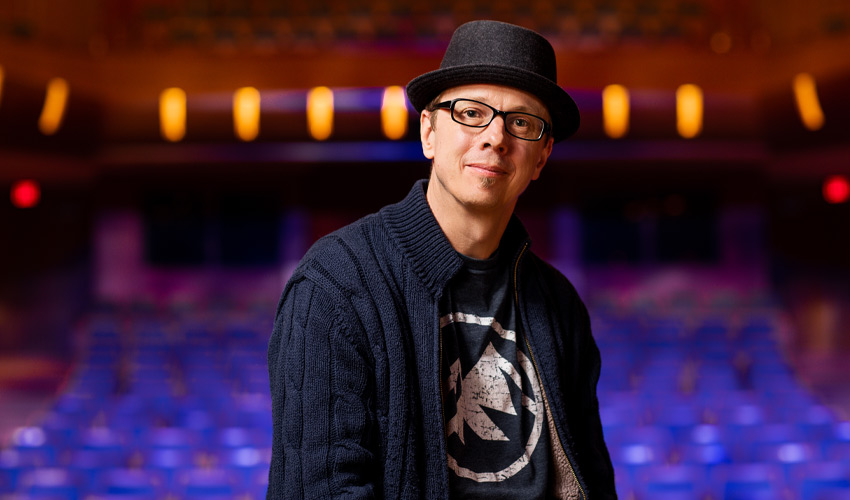 Craig Hall standing on stage in the Bella Concert Hall.