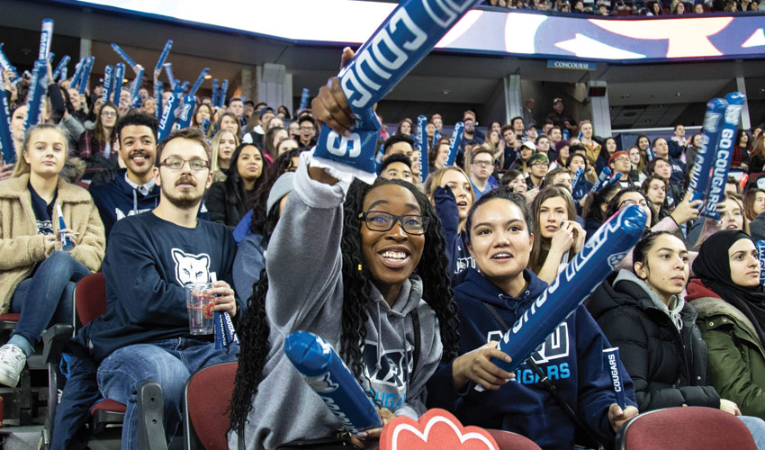 A group of friends in a packed Scotiabank Saddledome watching the Crowchild Classic.