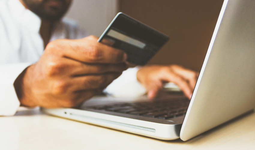 Photo of person inputting credit card information online.