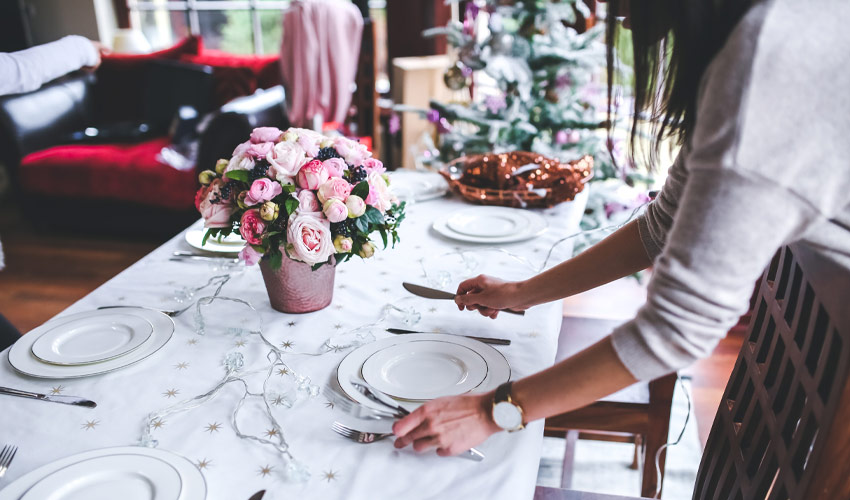 A woman setting a table.