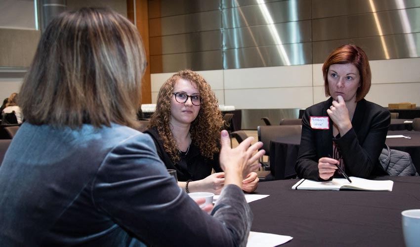 Participants in the International Women's Day conference at a table having a discussion