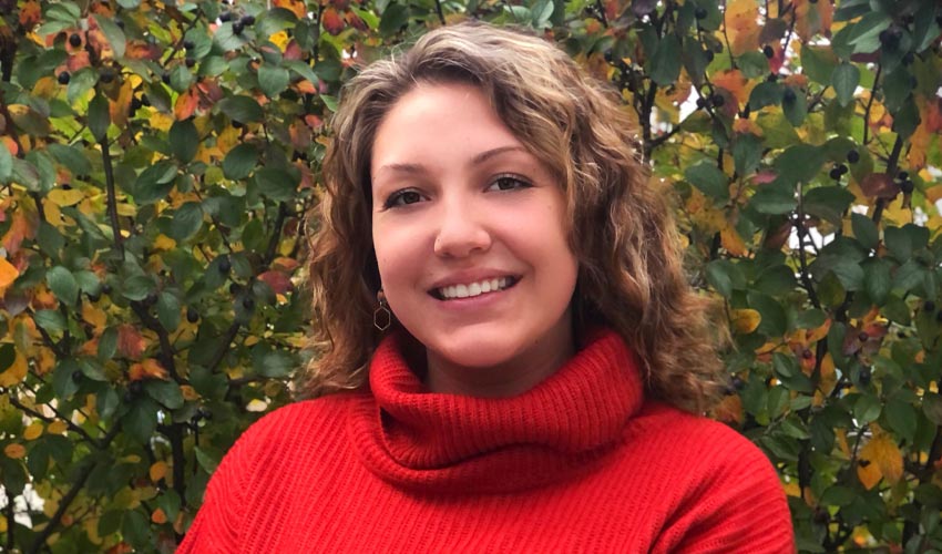 Kaylin McKay smiling with leafy trees in the background.