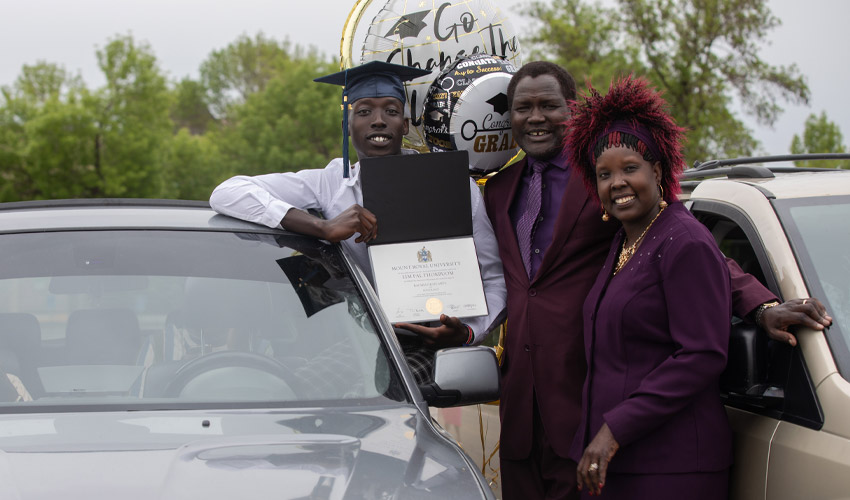 A proud Mount Royal University graduate smiles after Convocation with his family.