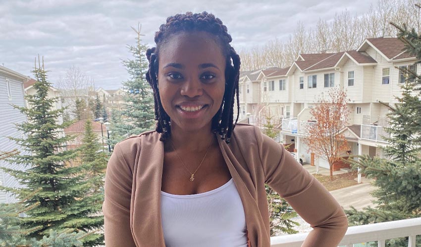 Maryjane Kanikwu smiling with a Calgary neighborhood in the background.