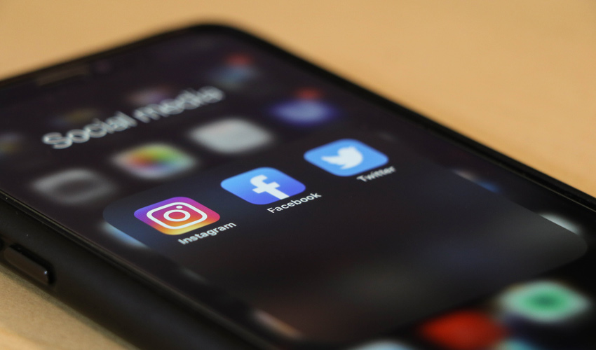An iPhone with the Instagram, Facebook and Twitter apps at the forefront.
