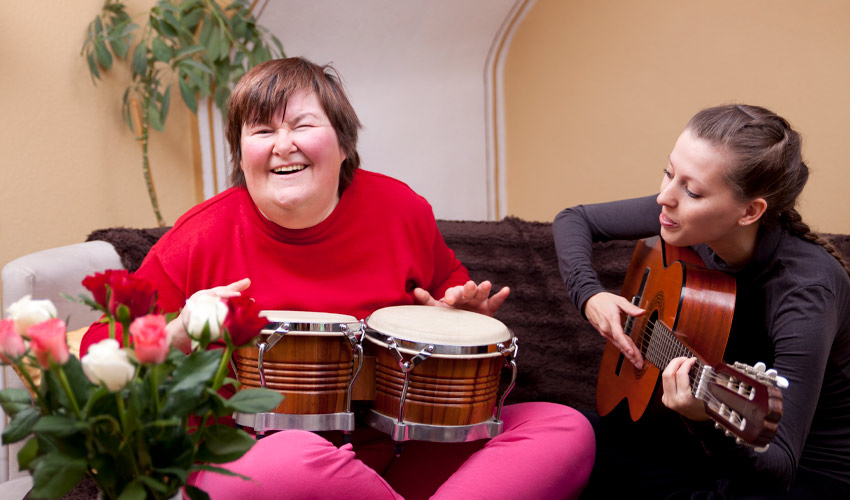 Two women making music during a music therapy session.