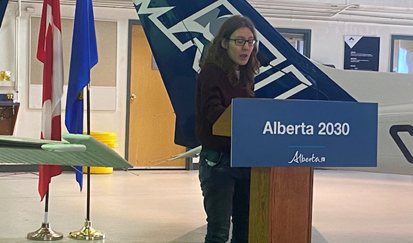 Student Olga Koldachenko addresses assembled university administrators and political leaders at the MRU Springbank hangar.