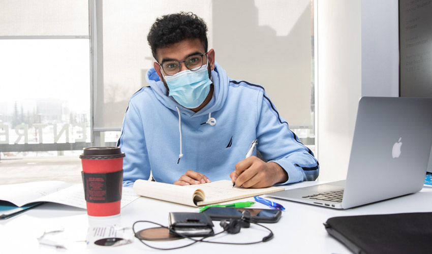 A University student wearing a mask in the Riddell Library & Learning Centre.