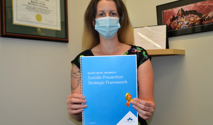 Rachelle McGrath holding a copy of the framework and yellow ribbons.