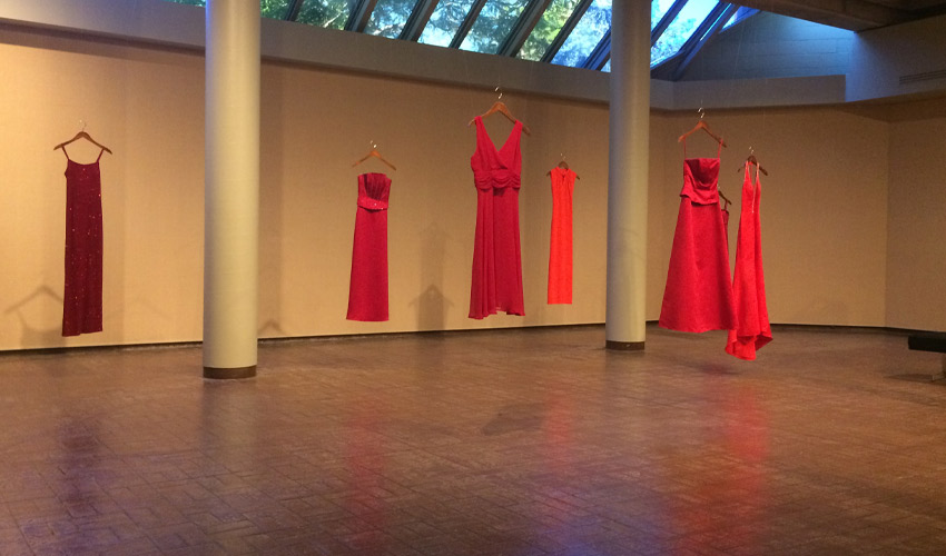 The REDress Project - red dresses hanging in an empty space.