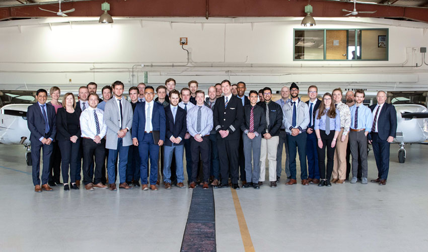 A large group of Mount Royal students posing in the hangar of MRU's Springbank Campus