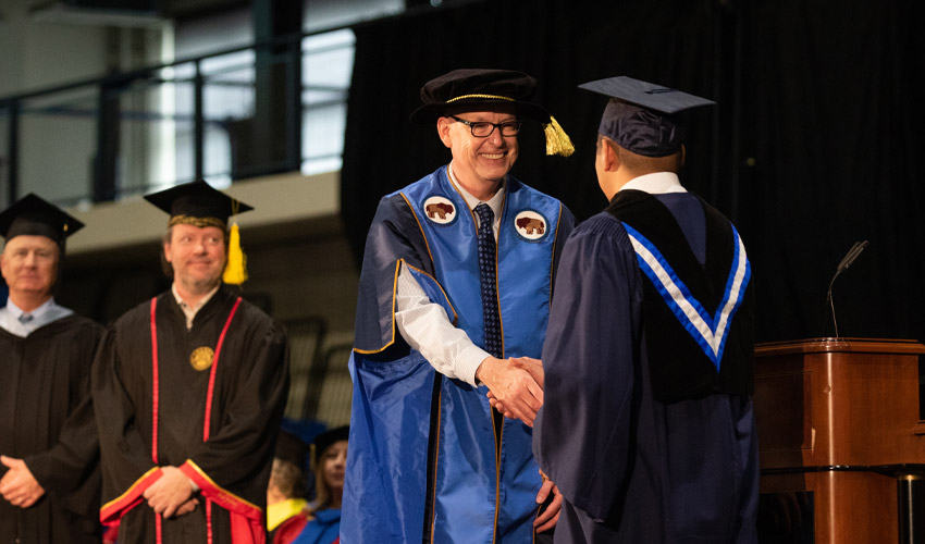 Dr. Rahilly congratulates graduands as they cross the stage at the 2022 convocation ceremony.