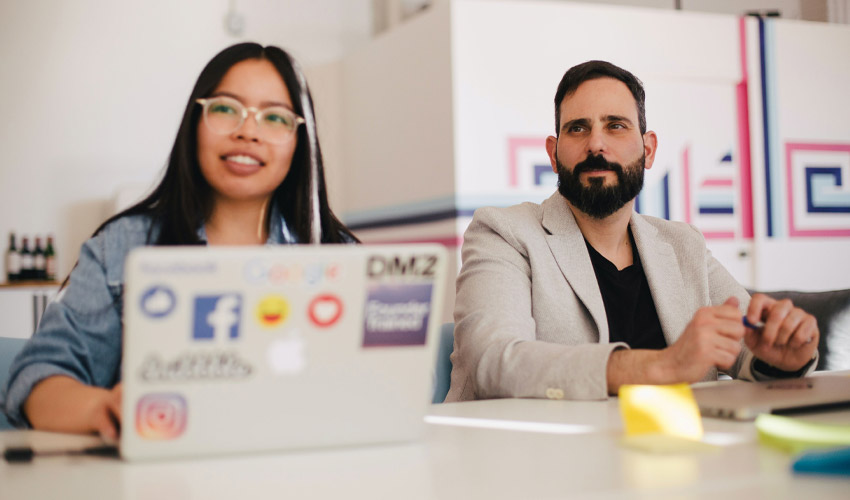 Woman and man sitting side-by-side at a meeting.
