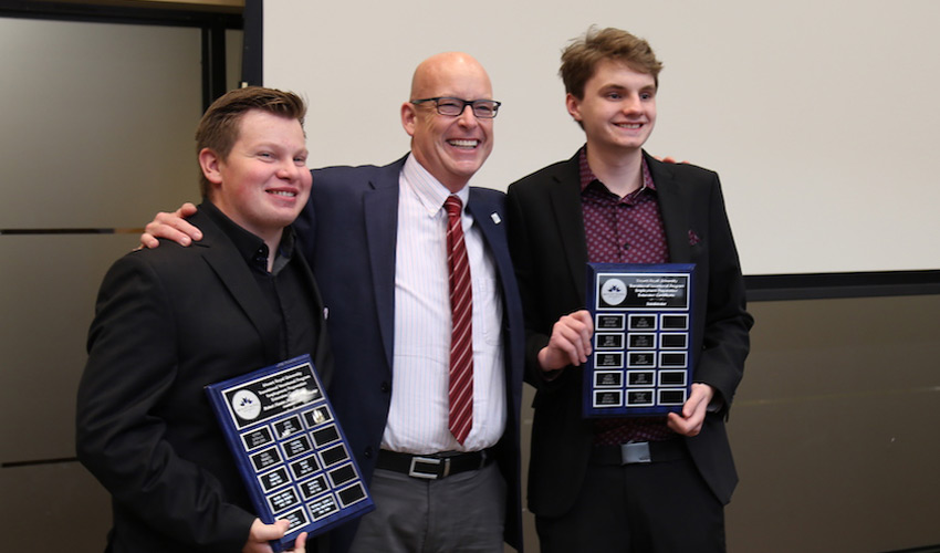 Mount Royal University President and Vice-Chancellor Tim Rahilly, PhD, centre, celebrates with Employment Preparation Certificate graduates Austin Repetwoski, left, and Nicholas Slade at the 2019 graduation event.