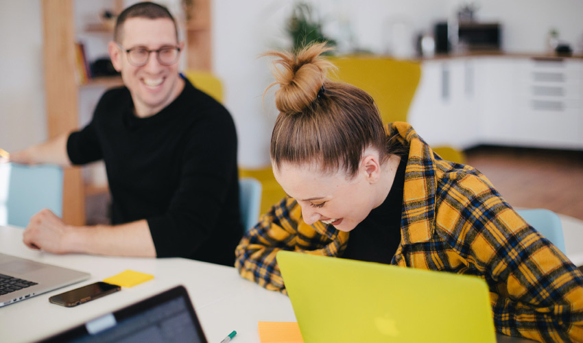 Two colleagues working and having a laugh.