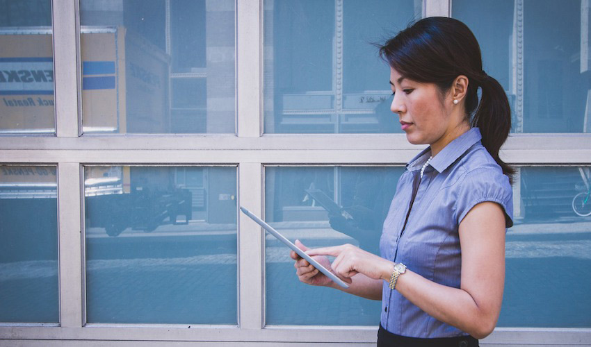 Photo of woman working on a tablet.