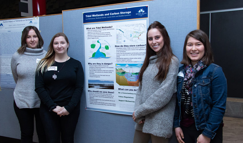 Students Maddie Summers, Madison Kuresh, Lois Kleinsasser, Lauren Oishie with their poster on Tidal Wetlands and Carbon Storage