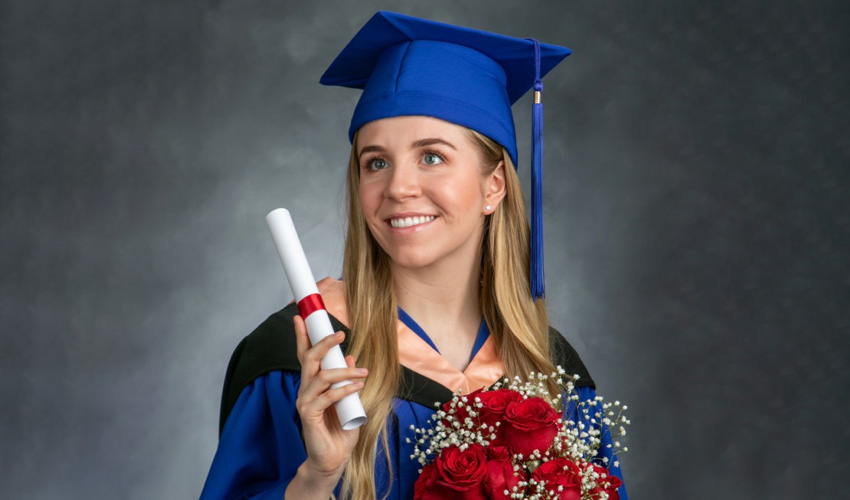 Zoe Letourneau in Mount Royal regalia holding her parchment.