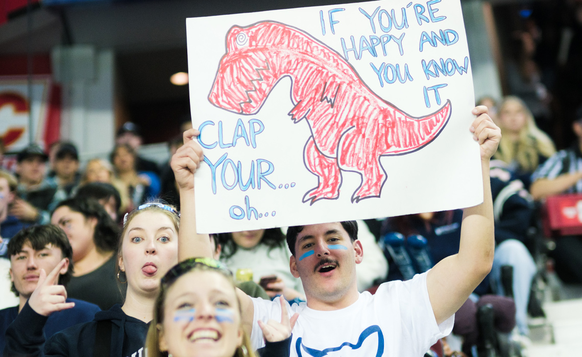 A Cougars fan gets creative with a sign poking fun at the University of Calgary Dinos mascot during the Crowchild Classic.