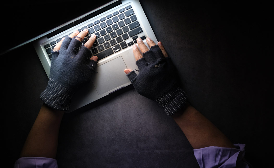 A person wearing open-finger gloves while using a laptop computer.