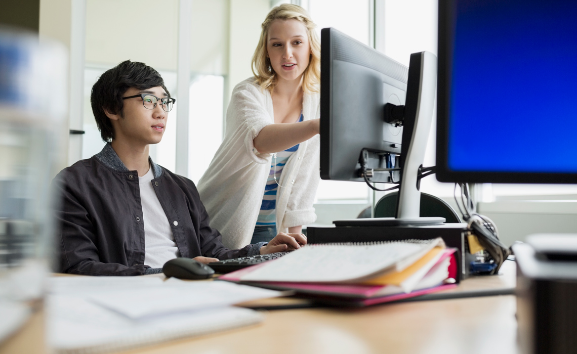 A man and woman collaborating, engaged in productive work together.