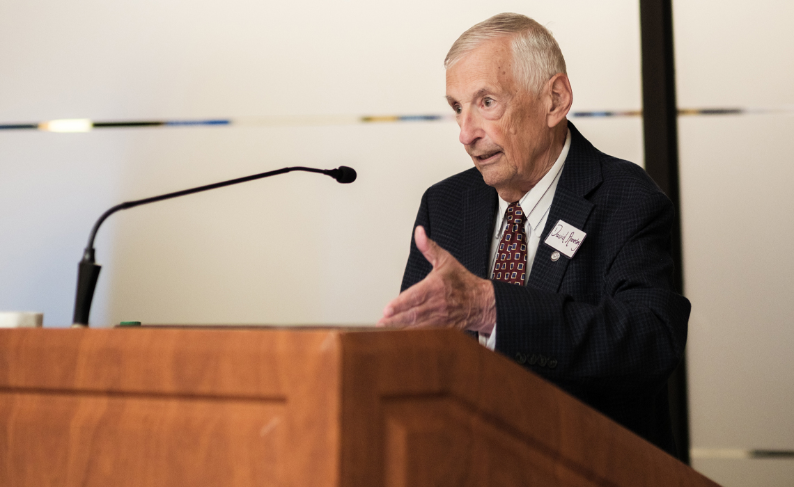 David Annesley in formal attire speaks at  at Mount Royal University.