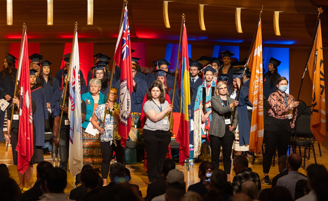 Procession led by flag bearers for each nation.