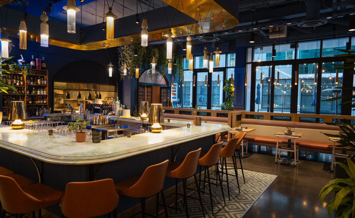 The interior of a Kama, showcasing a variety of drinks and a lively atmosphere.