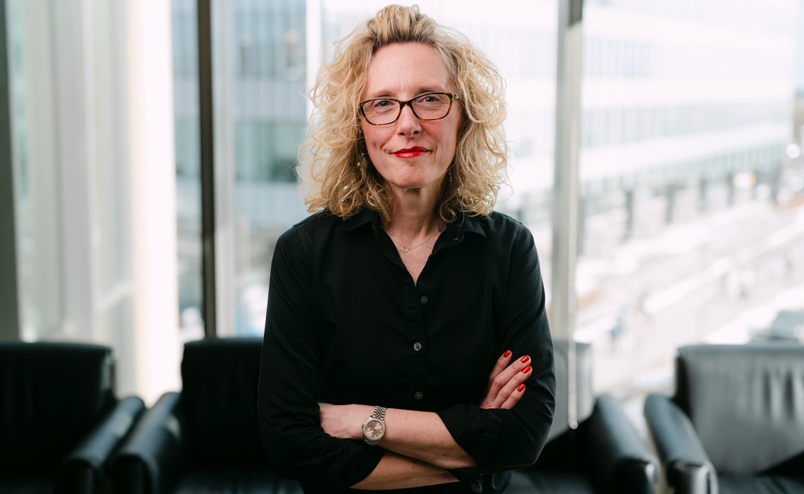 Mount Royal University professor and scholar Kari Roberts smiling while standing in the Riddell Library and Learning Centre.