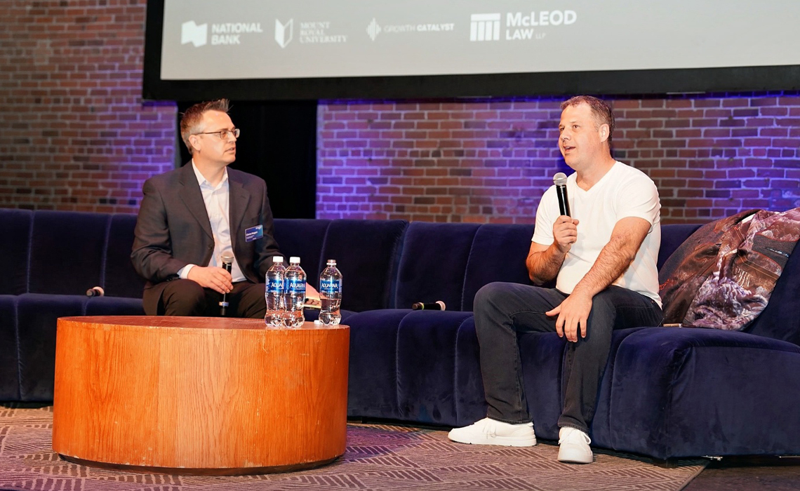 Two men seated on a couch, discussing and sharing ideas in a relaxed atmosphere.