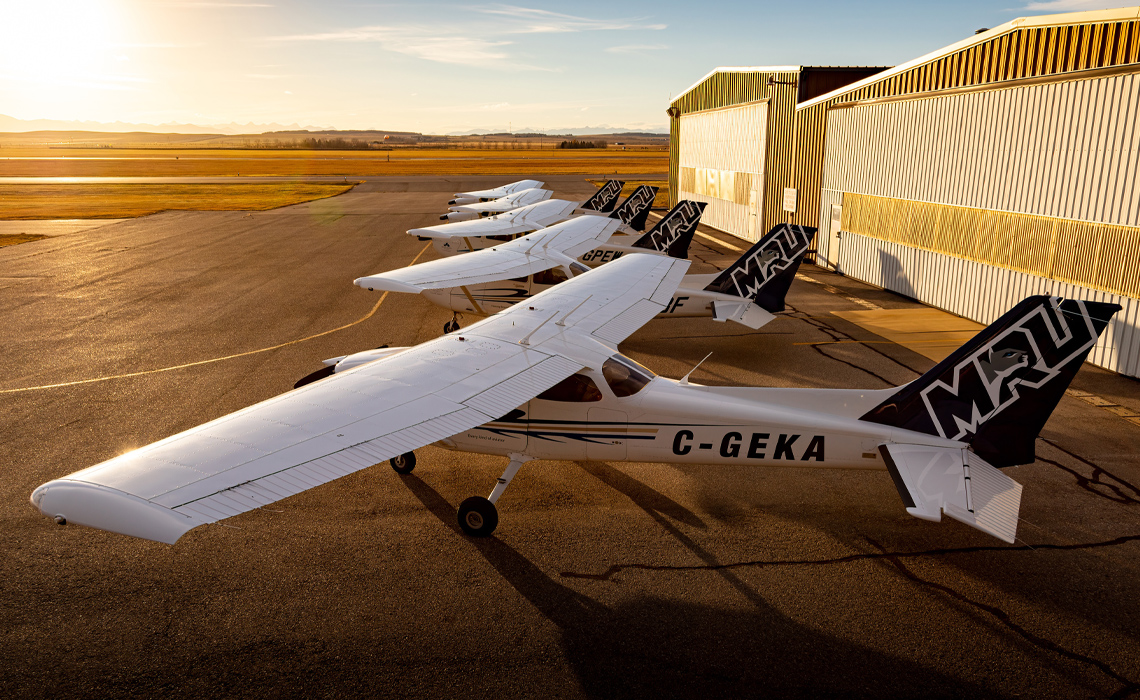 A row of planes parked neatly on a runway.